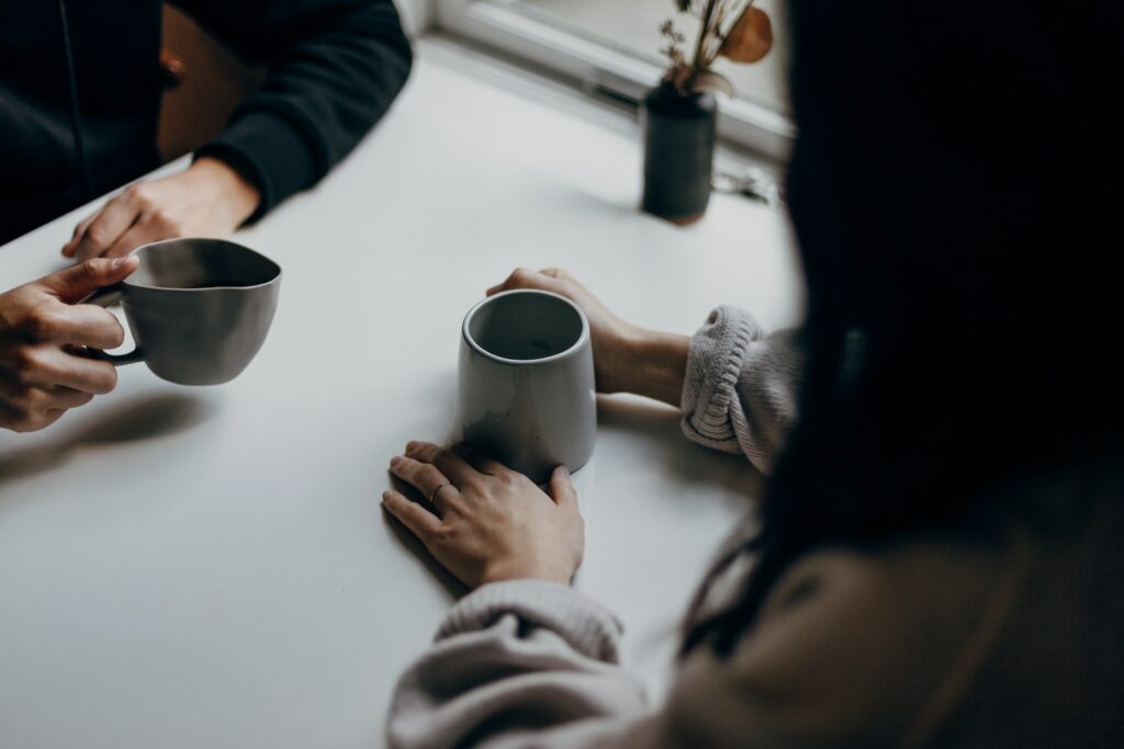 Two People In a Coaching Session with Coffee Cups